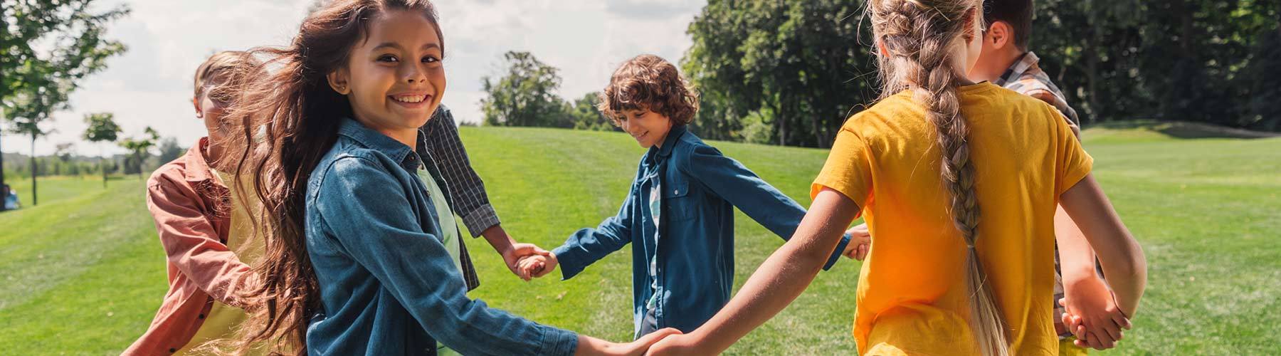 Selective focus of happy multicultural kids holding hands