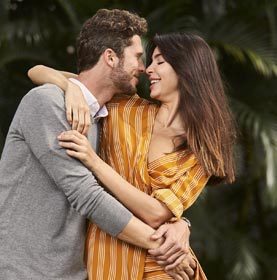 Couple embracing with desire in park, smiling