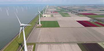 Offshore windmill park with clouds and a blue sky, windmill park in the ocean drone aerial view with wind turbine Flevoland Netherlands Ijsselmeer